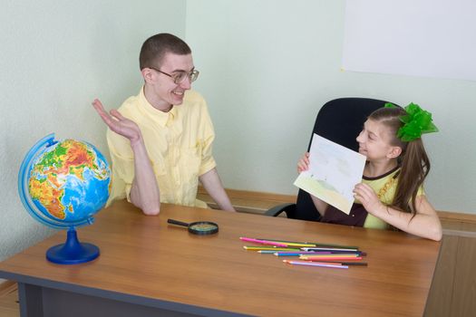 The girl shows new drawing to the brother