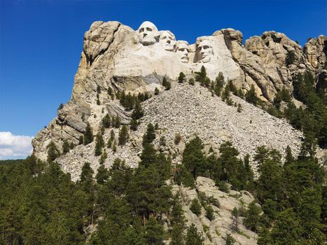 Mount Rushmore National Memorial with mountain and trees.