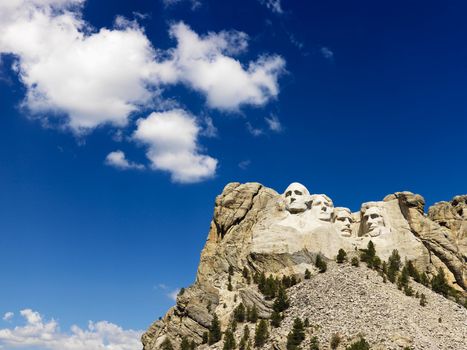 Mount Rushmore National Memorial with blue cloudy sky.