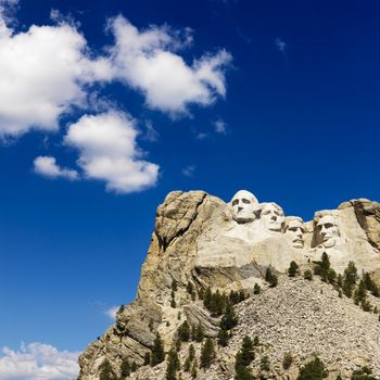 Mount Rushmore National Memorial with blue cloudy sky.