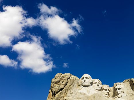 Mount Rushmore National Memorial with blue cloudy sky.