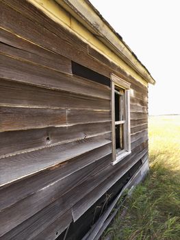 Side of abandoned wooden dilapidated house.