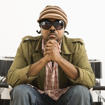 African-American mid-adult man wearing hat and sunglasses and looking at viewer.