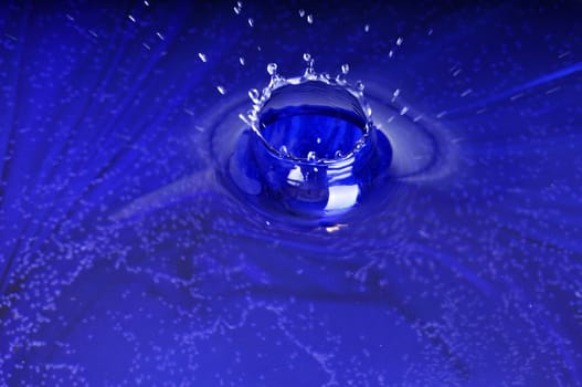 Falling of drops in water on a dark blue background