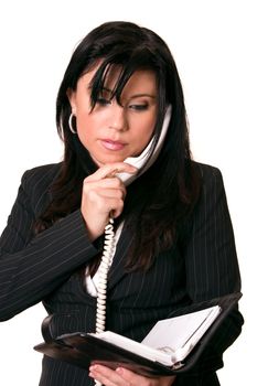 Businesswoman wearing a pale pink and light grey pinstripe black suit is on a phone call and checking her diary.