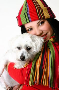 A beautiful smiling vibrant woman affectionately cuddling a pet white maltese terrier dog.