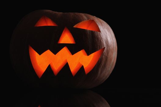  pumpkin with lighting candle inside on black background