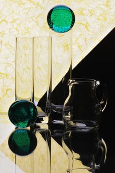 Glass glasses and jug on a multi-coloured background