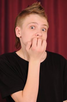 Portrait of the surprised teenager in a black vest