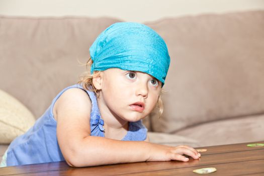 Cute little European girl playing and watching TV at home.