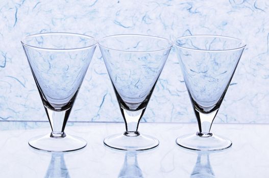 Transparent empty glasses on blue background