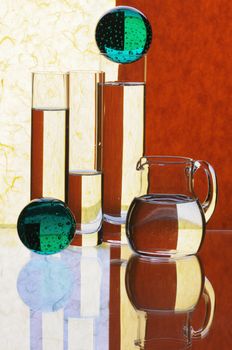 Glass glasses and jug on a multi-coloured background