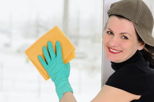 The woman with a yellow rag  washes a window