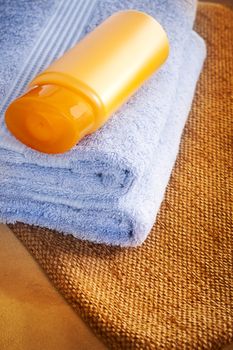 Towel and shampoo on the brown table