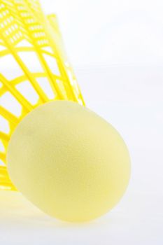 A bright yellow shuttlecock for badminton isolated on white background.