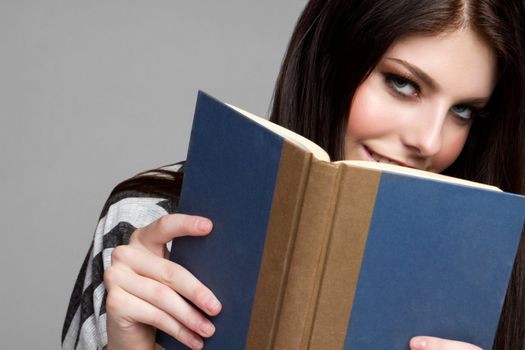 Pretty teen girl reading book