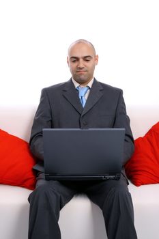 businessman working on the sofa with red pillows