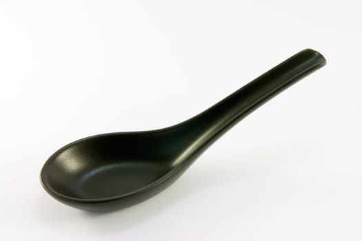 Black chinese china soup spoon on a white background