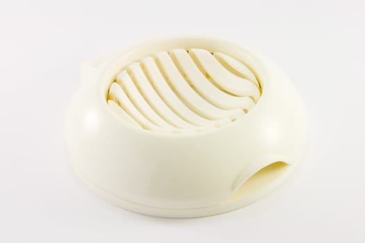 White plastic egg slicer on a whit background