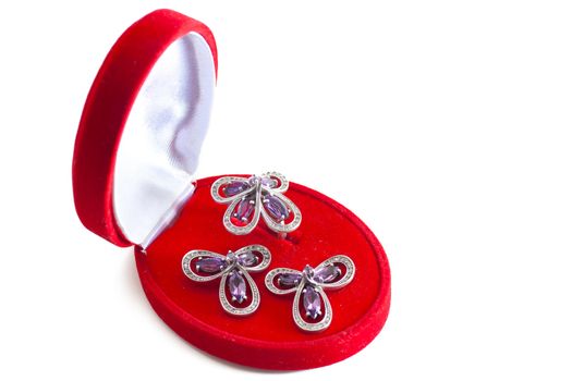 Closed gift box with ring and two earrings inside isolated over white