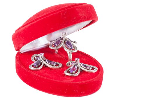 Closed gift box with ring and earrings inside isolated over white