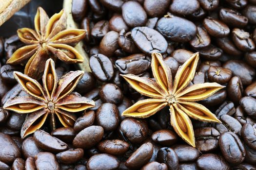 Background of gourmet coffee ingredients with star anise and whole coffee beans. Selective focus on lower portion of image with shallow depth of field.