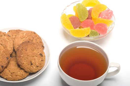 Tea colour fruit candy and cookies close up