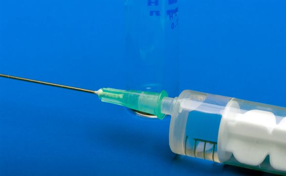 Syringe and ampoule on a dark blue background.