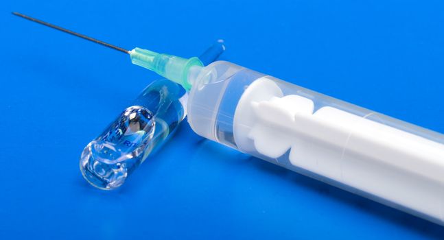 Syringe and ampoule on a dark blue background.