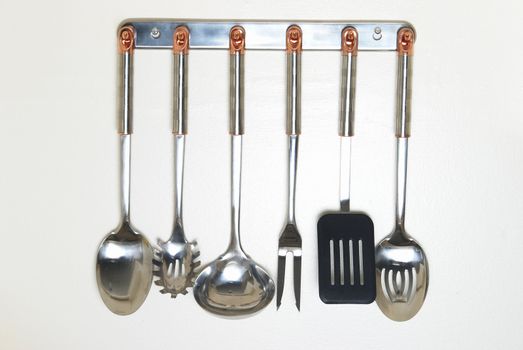 A rack of kitchen utensils hanging on the wall.