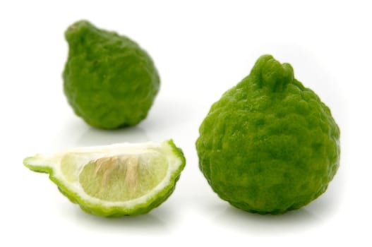 kaffir lime (Citrus hystrix). Whole fruit and section. Shot on white.