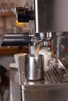 Industrial espresso machine steaming milk and filtering coffee