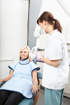 Female dental assistant taking oral x-ray of a patient