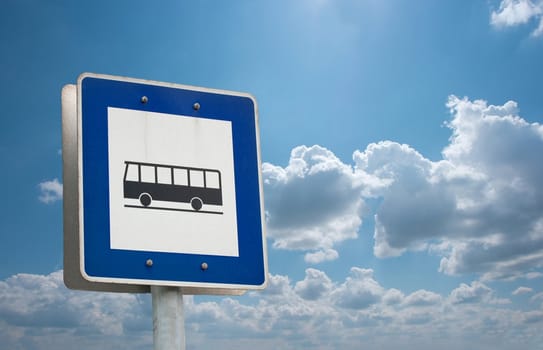 Bus stop sign against blue sky