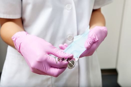 Midsection of a female dentist holding plaque remover and angled mirror