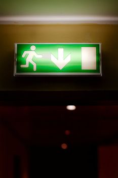 Emergency exit sign glowing in a corridor