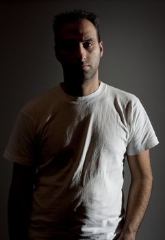 dark image of a no shaved dangerous looking guy in a rude pose