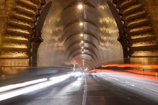 Heavy traffic entering a tunnel by night, motion blur