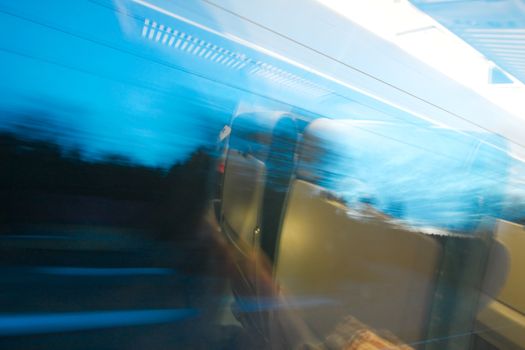 Traveling by train at night, wagon interior reflection on the window, motion-blurred landscape outside