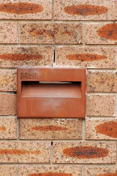 red mailbox in red brick wall, detail photo