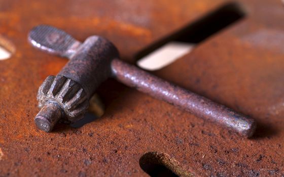 Antique bench press key on a rusted base