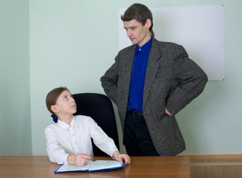 Teacher in a suit and schoolgirl with book