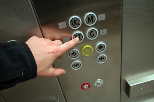 man hand pushing B2 button in chrome elevator