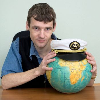 Man with the globe and a uniform cap