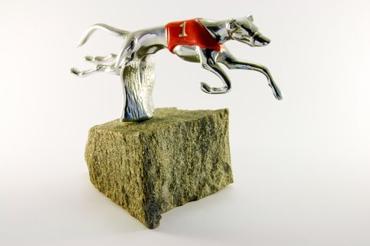 Silver number one greyhound with red jacket mounted on granite with a white background