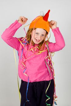 cheerfull happy young girl decorated with colorful confetti on gray background