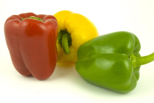 Yellow and green and red bell peppers isolated on white background