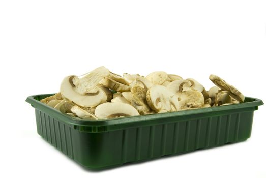 Sliced champignon mushrooms in green pack isolated on white background