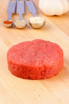 fresh raw beef burger patty,  with ingredients on background 