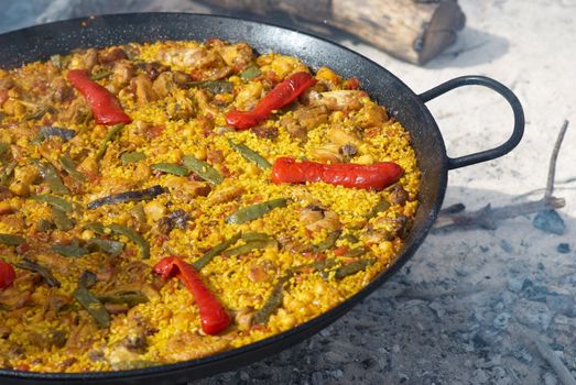 Traditional outdoor cooking of paella on open fire